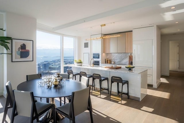 dining area featuring floor to ceiling windows and wood-type flooring