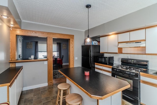 50 Duryea St, Springfield, MA 01104 - kitchen featuring black appliances, dark countertops, under cabinet range hood, white cabinetry, and decorative backsplash