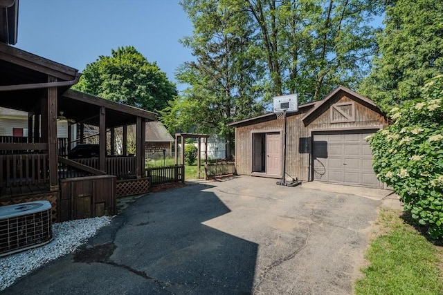 50 Duryea St, Springfield, MA 01104 - view of patio featuring asphalt driveway, central AC, an outbuilding, and a garage