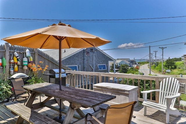 deck featuring outdoor dining area, fence, and grilling area