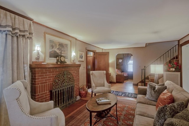 1142 Longmeadow St, Longmeadow, MA 01106 - living room featuring wood finished floors, stairway, a fireplace, and arched walkways