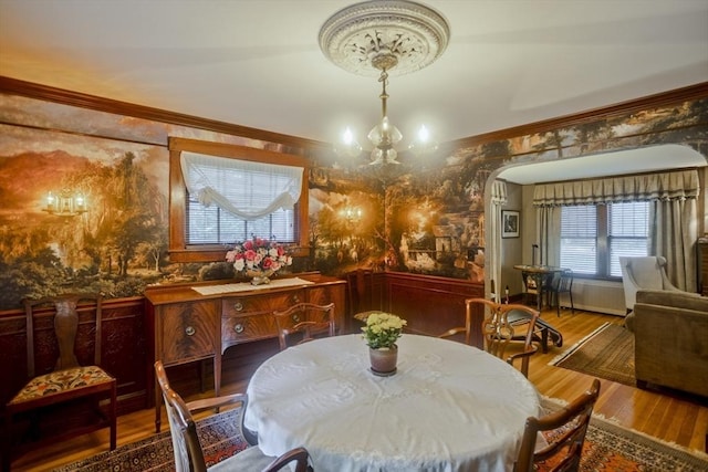 1142 Longmeadow St, Longmeadow, MA 01106 - dining area with a chandelier, ornamental molding, wood finished floors, and arched walkways