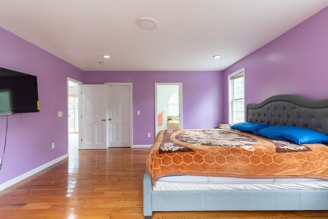 bedroom featuring connected bathroom and wood-type flooring