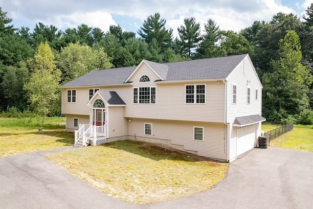 bi-level home featuring a garage and a front lawn