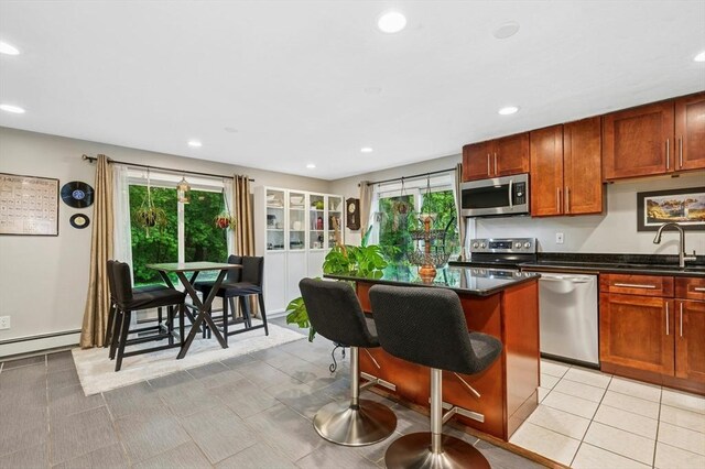 41 Dick Dr, Worcester, MA 01609 - kitchen featuring appliances with stainless steel finishes, a sink, dark countertops, a breakfast bar area, and baseboard heating