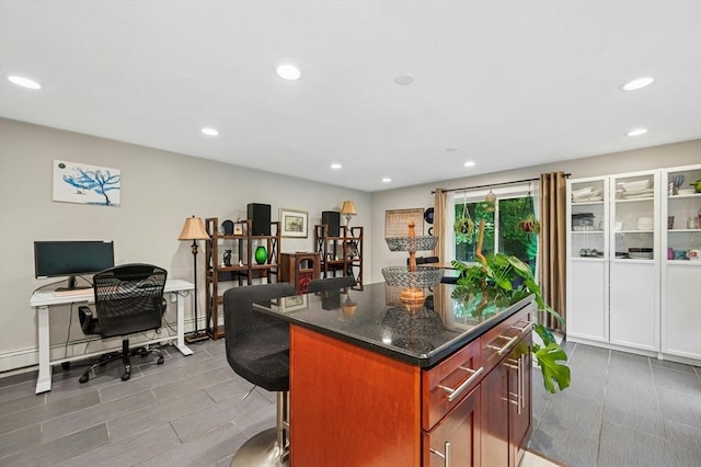 41 Dick Dr, Worcester, MA 01609 - kitchen with a desk, a kitchen island, recessed lighting, a breakfast bar, and dark stone countertops