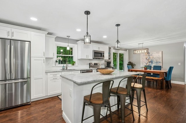 41 Dick Dr, Worcester, MA 01609 - kitchen featuring stainless steel appliances, a kitchen island, white cabinets, dark wood-type flooring, and a breakfast bar