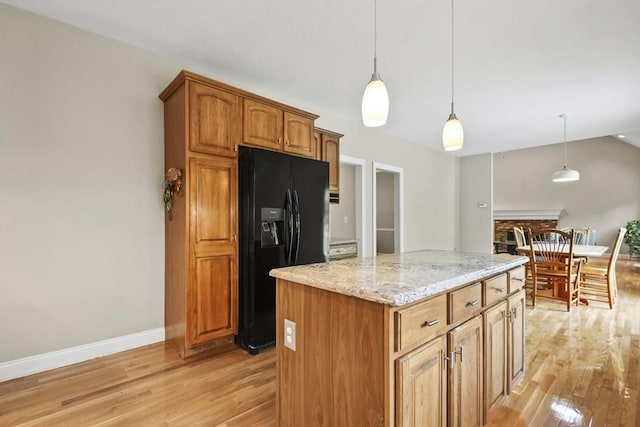 17 Sean Mikeal Way, Grafton, MA 01519 - kitchen featuring black fridge, light wood-style flooring, decorative light fixtures, light stone counters, and a kitchen island