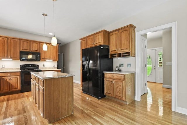 17 Sean Mikeal Way, Grafton, MA 01519 - kitchen with black appliances, light wood-type flooring, brown cabinets, a kitchen island, and pendant lighting