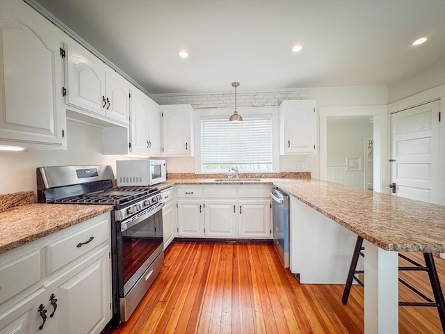 19 Center St, Weymouth, MA 02189 - kitchen featuring appliances with stainless steel finishes, a peninsula, white cabinets, and recessed lighting
