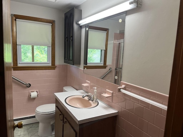 46 Mill Rd, Dudley, MA 01571 - bathroom with baseboard heating, tile walls, toilet, vanity, and a shower with shower door
