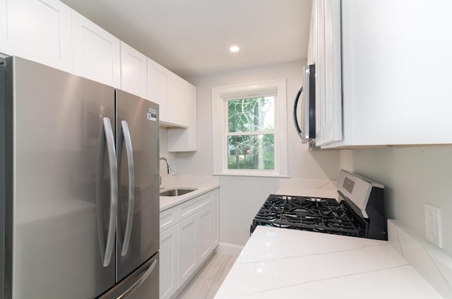 7 Cliff St, Attleboro, MA 02703 - kitchen with appliances with stainless steel finishes, white cabinetry, light stone countertops, and recessed lighting