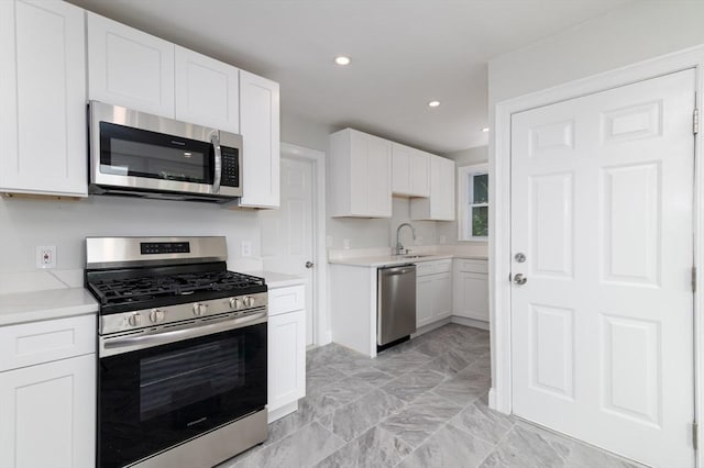 7 Cliff St, Attleboro, MA 02703 - kitchen with stainless steel appliances, white cabinets, light countertops, recessed lighting, and light marble finish floors