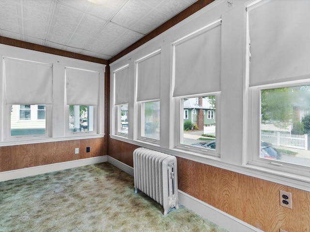 unfurnished sunroom with radiator and plenty of natural light