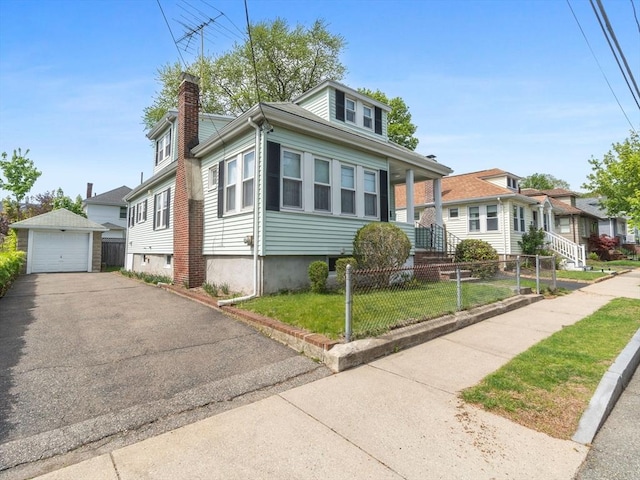 bungalow-style home featuring an outbuilding, a chimney, a garage, driveway, and a residential view