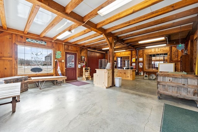 miscellaneous room with concrete flooring and wood walls