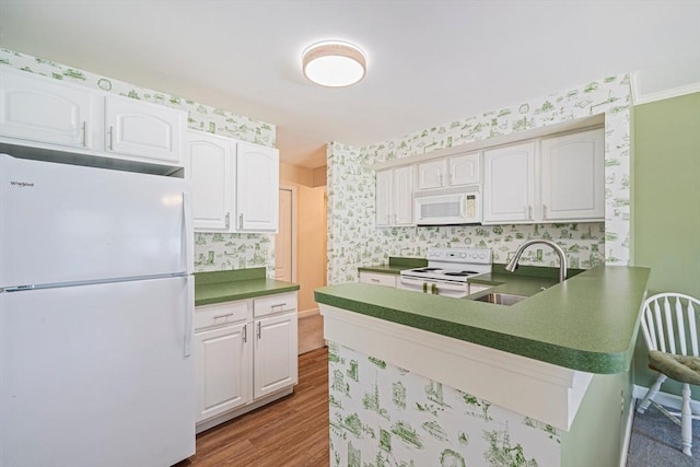 37 Hastings St Unit 207, Boston, MA 02132 - kitchen featuring white appliances, dark countertops, a peninsula, white cabinets, and wallpapered walls