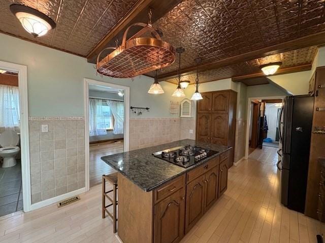 17 Olcott St, Watertown, MA 02472 - kitchen with tile walls, an ornate ceiling, black appliances, and light wood-type flooring