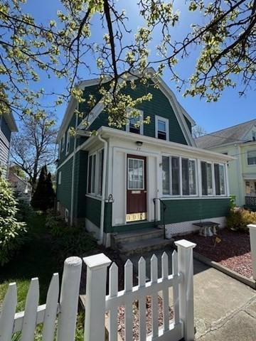17 Olcott St, Watertown, MA 02472 - view of front facade with a sunroom, a gambrel roof, and a fenced front yard