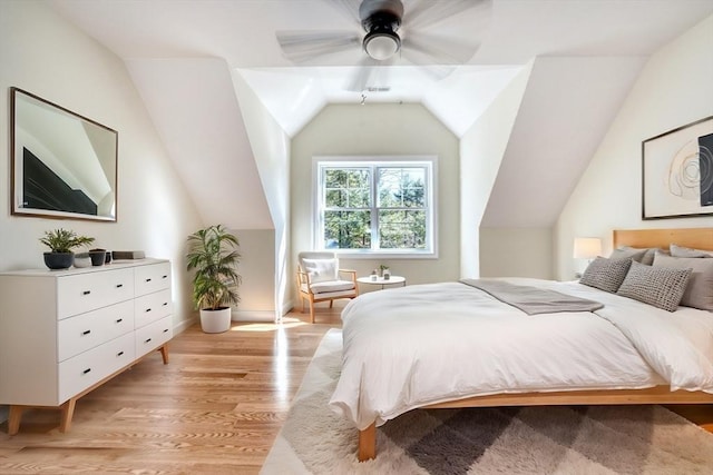 bedroom with vaulted ceiling, light wood finished floors, and ceiling fan