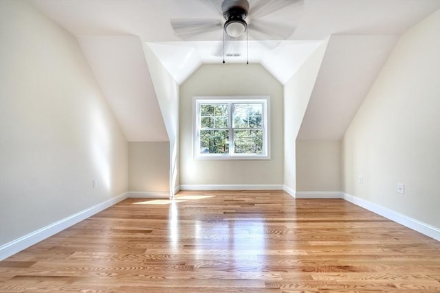 additional living space featuring vaulted ceiling, wood finished floors, baseboards, and ceiling fan