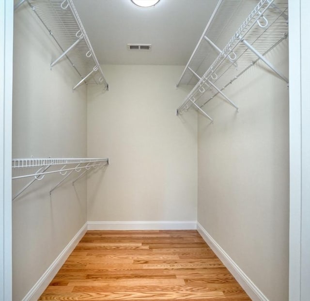 walk in closet with light wood-style flooring and visible vents