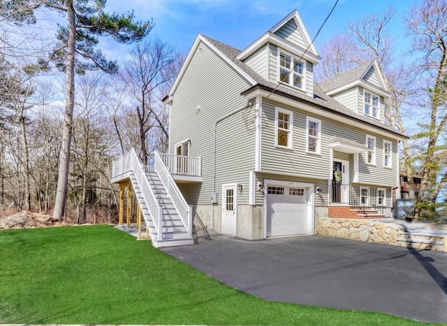 view of front of property with stairway, aphalt driveway, a front lawn, a wooden deck, and a garage