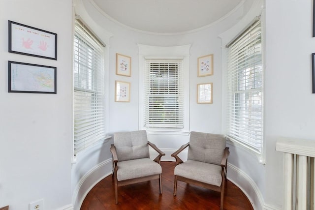 living area with hardwood / wood-style flooring and ornamental molding