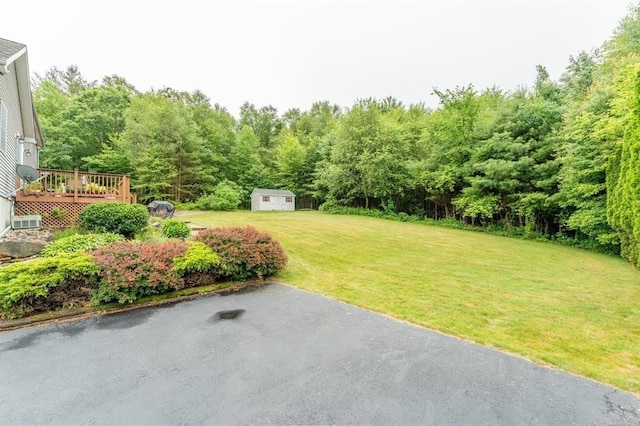 39 Grey Fox Lndg, Woodstock, CT 06281 - view of green lawn with a storage shed, a deck, and a wooded view