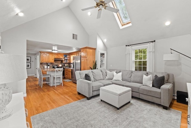 45 S Elm St, West Bridgewater, MA 02379 - living area with ceiling fan, high vaulted ceiling, light wood-style floors, a skylight, and a baseboard heating unit