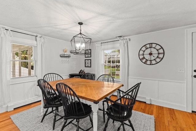 45 S Elm St, West Bridgewater, MA 02379 - dining room with a baseboard heating unit, light wood-style flooring, crown molding, a chandelier, and a decorative wall