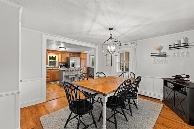 45 S Elm St, West Bridgewater, MA 02379 - dining area with light wood finished floors, a chandelier, baseboard heating, crown molding, and a textured ceiling
