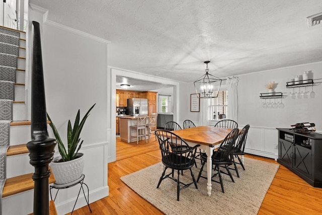 45 S Elm St, West Bridgewater, MA 02379 - dining area with ornamental molding, a chandelier, light wood-type flooring, a baseboard radiator, and a textured ceiling