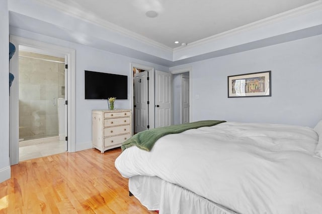 bedroom featuring baseboards, light wood finished floors, connected bathroom, and crown molding