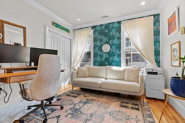 home office with wood finished floors, ornamental molding, visible vents, baseboards, and wallpapered walls