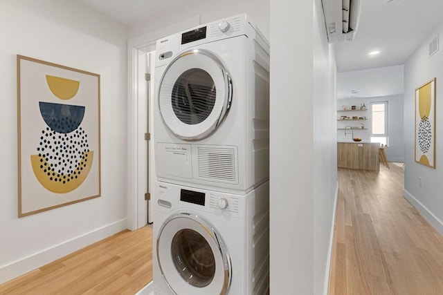 213 Harvard Unit 4, Cambridge, MA 02139 - laundry room featuring stacked washer / drying machine, light wood-style floors, and recessed lighting