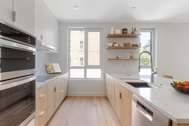 213 Harvard Unit 4, Cambridge, MA 02139 - kitchen featuring stainless steel appliances, open shelves, light wood-type flooring, and light brown cabinetry