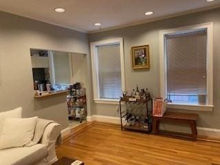 living area with recessed lighting, ornamental molding, baseboards, and wood finished floors