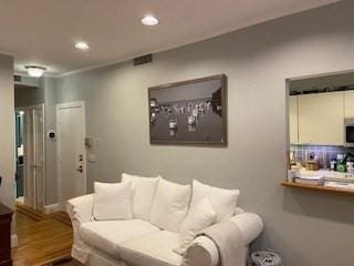 living area featuring recessed lighting, visible vents, and wood finished floors