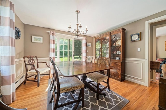 771 Ferry St, Marshfield, MA 02050 - dining area with light wood-style flooring, a chandelier, wainscoting, a decorative wall, and a baseboard heating unit