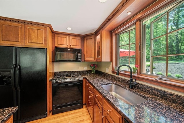 771 Ferry St, Marshfield, MA 02050 - kitchen with black appliances, a sink, brown cabinetry, dark stone countertops, and recessed lighting