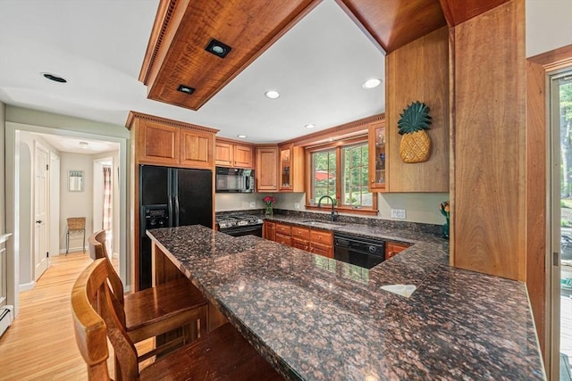 771 Ferry St, Marshfield, MA 02050 - kitchen featuring black appliances, dark stone counters, brown cabinets, a sink, and recessed lighting