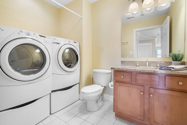 bathroom with toilet, vanity, tile patterned floors, and washing machine and clothes dryer