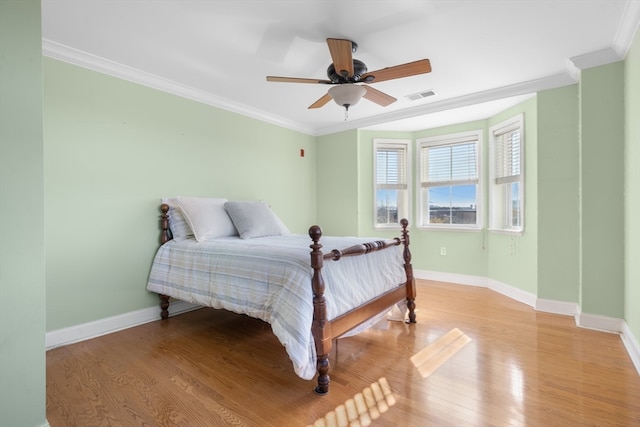 bedroom with ceiling fan, ornamental molding, and light wood-type flooring