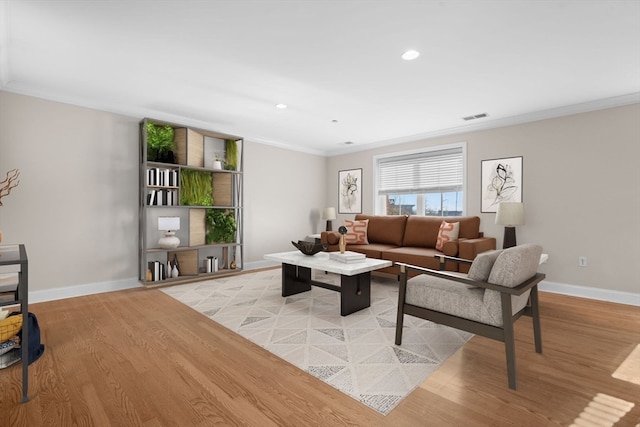 living room with light hardwood / wood-style floors and ornamental molding