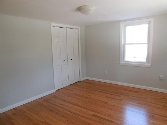 unfurnished bedroom with a closet and hardwood / wood-style flooring