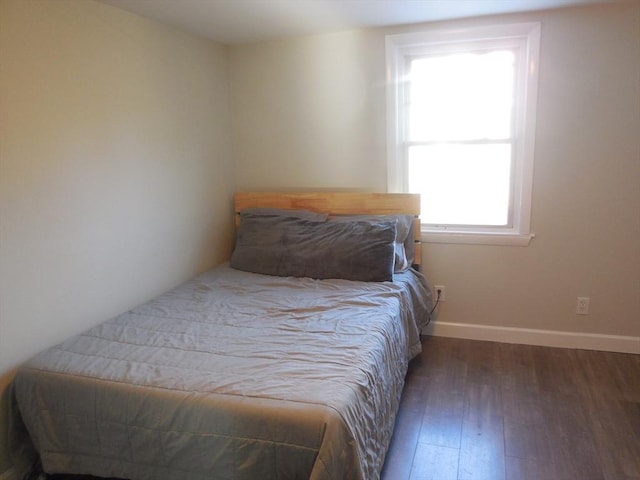 bedroom with dark wood-type flooring