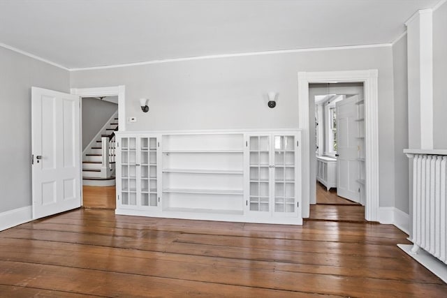 interior space with dark hardwood / wood-style flooring, crown molding, and radiator heating unit