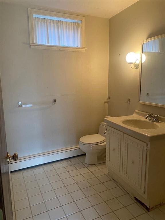 bathroom featuring a baseboard heating unit, tile patterned flooring, vanity, and toilet