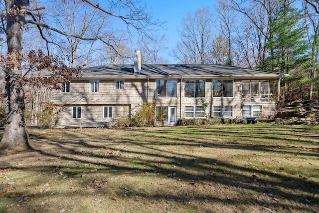 back of property featuring a sunroom and a lawn